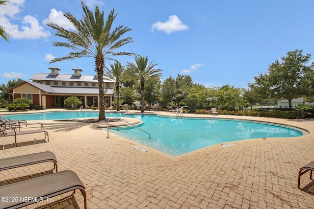 pool with a patio area and fence