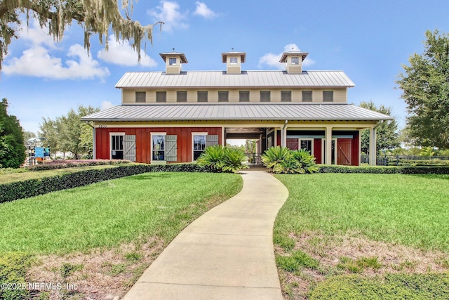 view of front of property featuring a standing seam roof, metal roof, board and batten siding, and a front yard