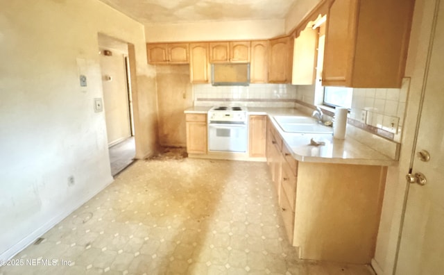 kitchen with sink, oven, decorative backsplash, electric range, and light brown cabinets