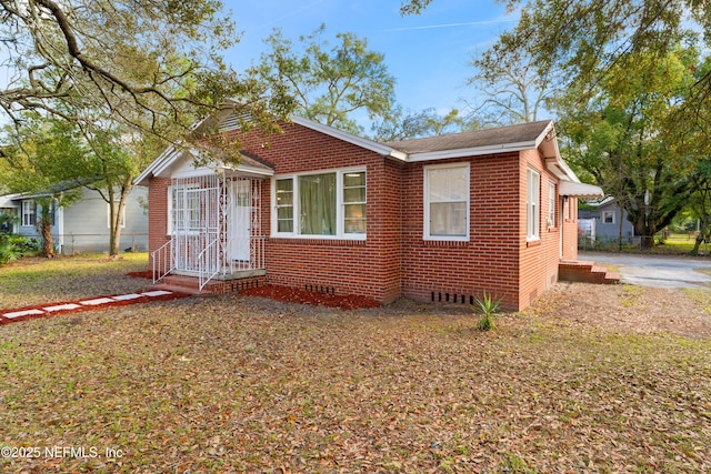 bungalow-style house featuring brick siding and crawl space