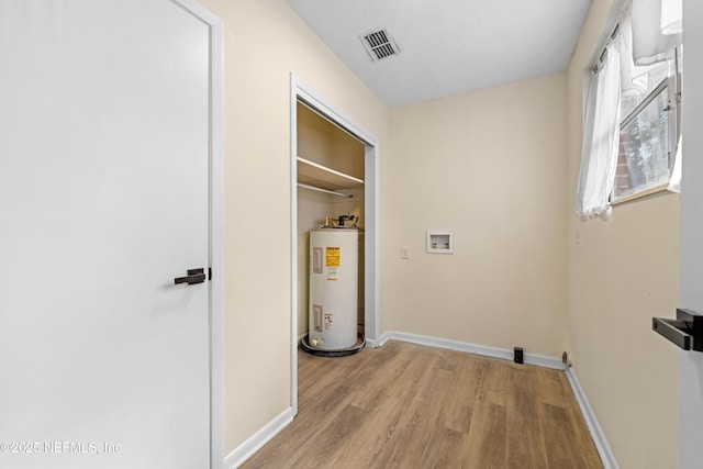 washroom featuring washer hookup, light wood finished floors, visible vents, electric water heater, and baseboards