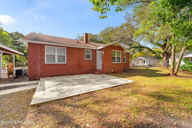 rear view of house featuring cooling unit, a patio area, brick siding, and entry steps