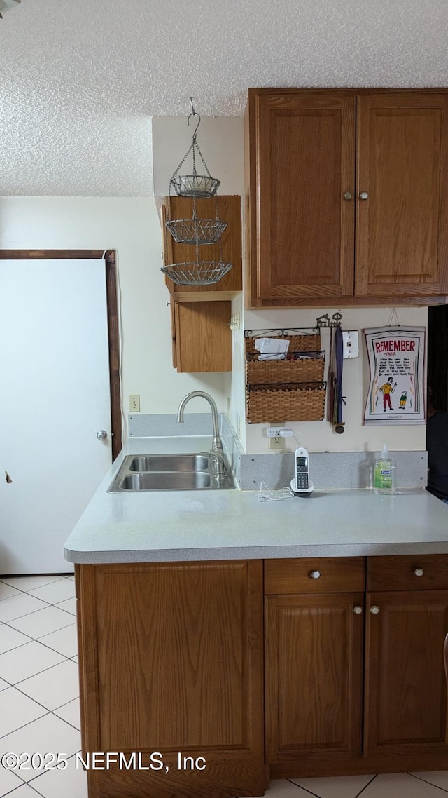 kitchen featuring sink, a textured ceiling, and light tile patterned flooring