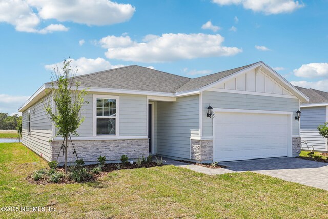 25 Ararat Dr, Palm Coast, FL 32137 - view of front of house featuring an attached garage, stone siding, a front yard, and decorative driveway