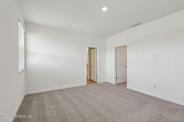 25 Ararat Dr, Palm Coast, FL 32137 - unfurnished room featuring a wealth of natural light, baseboards, light carpet, and visible vents