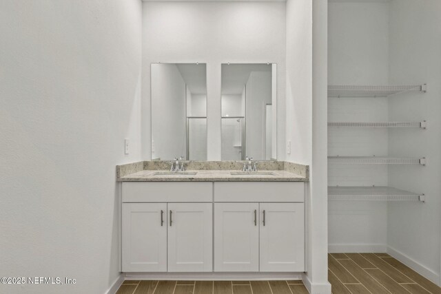 25 Ararat Dr, Palm Coast, FL 32137 - full bath with baseboards, wood finish floors, a sink, and double vanity