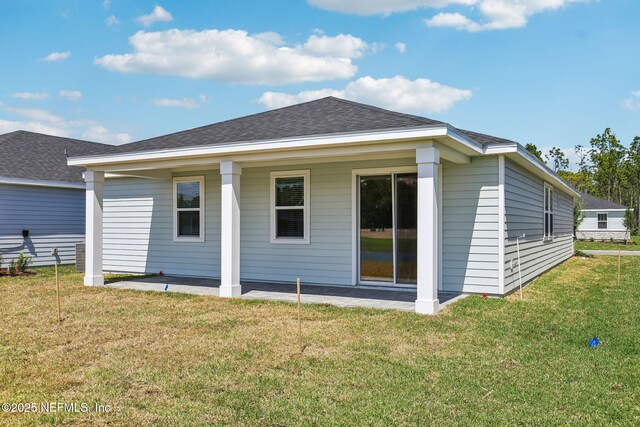25 Ararat Dr, Palm Coast, FL 32137 - back of property featuring a lawn, a patio area, and a shingled roof