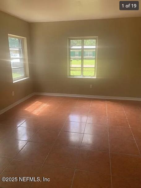 spare room with dark tile patterned flooring