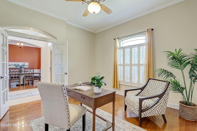 office area with crown molding, ceiling fan with notable chandelier, light wood-type flooring, and french doors