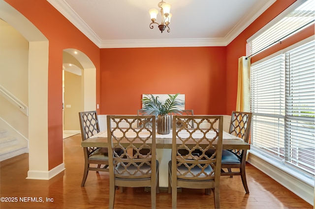 dining room featuring an inviting chandelier, ornamental molding, and wood-type flooring