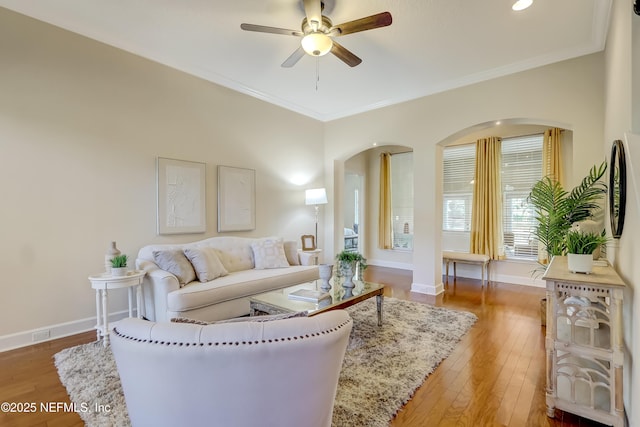 living room featuring hardwood / wood-style flooring, ceiling fan, and ornamental molding