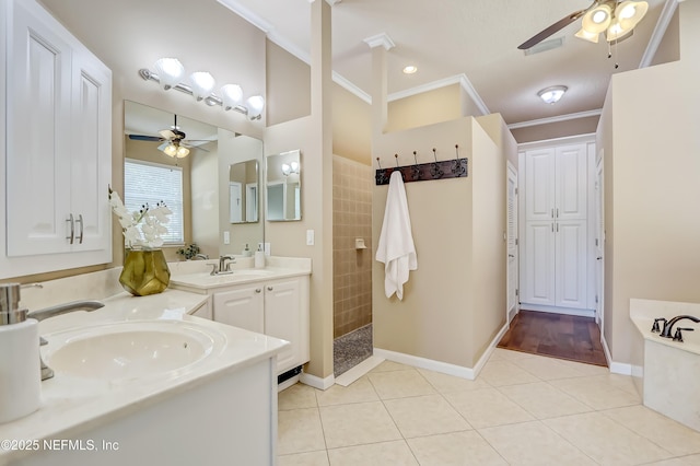 bathroom with crown molding, ceiling fan, a tile shower, vanity, and tile patterned floors