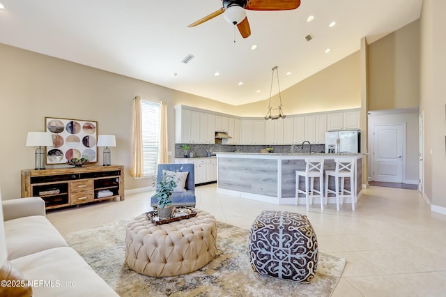 living room with ceiling fan, sink, high vaulted ceiling, and light tile patterned floors