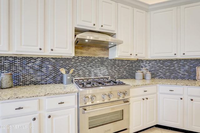 kitchen with white cabinets, light stone countertops, stainless steel stove, and decorative backsplash