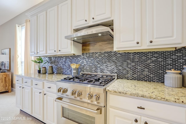 kitchen featuring white cabinetry, light tile patterned floors, light stone counters, and gas stove