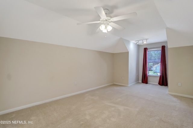 additional living space featuring lofted ceiling, light carpet, and ceiling fan