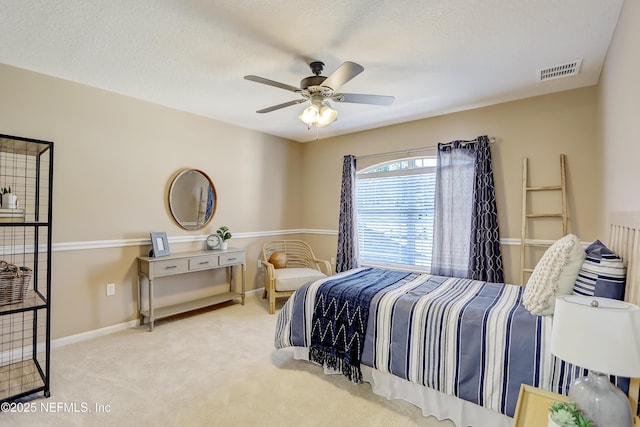 bedroom with ceiling fan, carpet flooring, and a textured ceiling