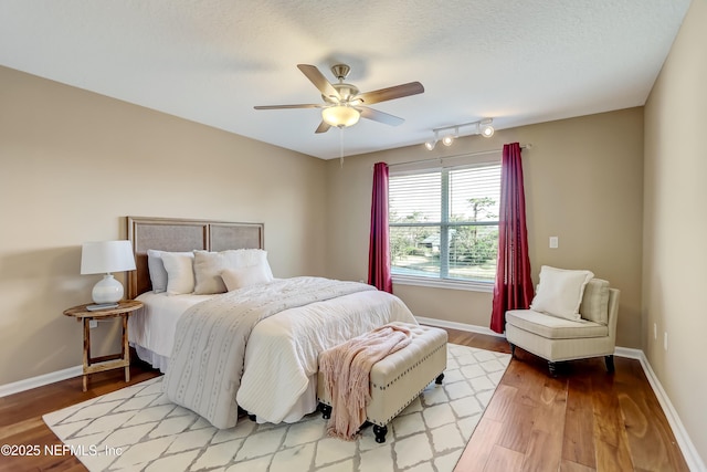 bedroom featuring a textured ceiling, ceiling fan, and light wood-type flooring