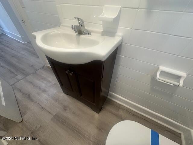 939 Jasmine Pl, Jacksonville, FL 32205 - bathroom with vanity, wood-type flooring, tile walls, and toilet