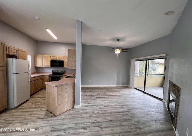 kitchen with white refrigerator, stainless steel electric range oven, light brown cabinetry, and kitchen peninsula