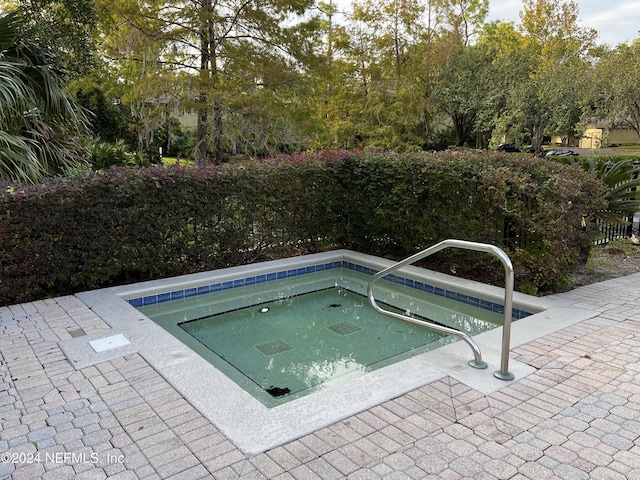 view of swimming pool featuring an in ground hot tub