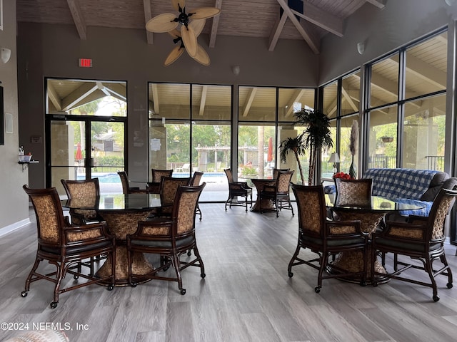 dining space with ceiling fan, vaulted ceiling with beams, wooden ceiling, and light hardwood / wood-style floors