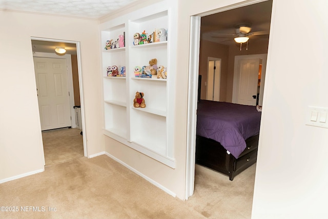 corridor featuring light colored carpet and built in shelves