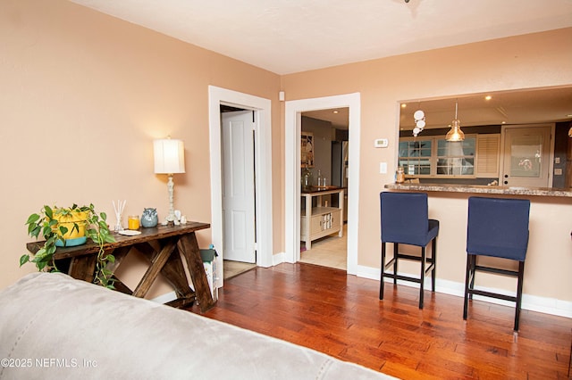 kitchen featuring hanging light fixtures, hardwood / wood-style flooring, and a breakfast bar