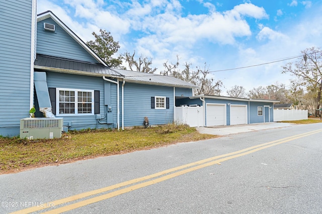 view of side of home with cooling unit and a garage