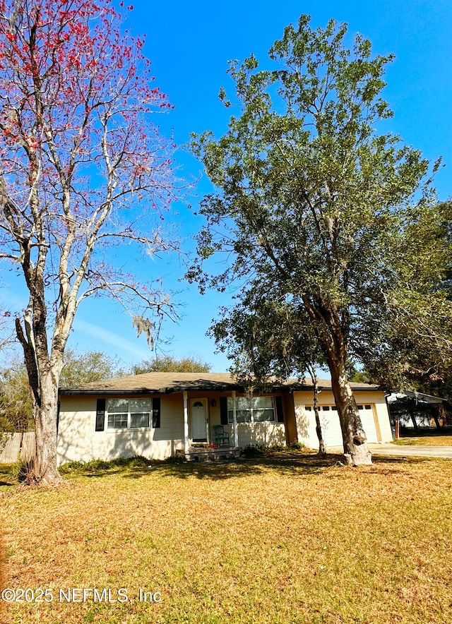 ranch-style house featuring a garage and a front yard