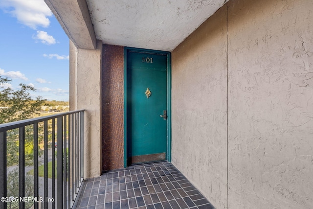 view of exterior entry featuring a balcony