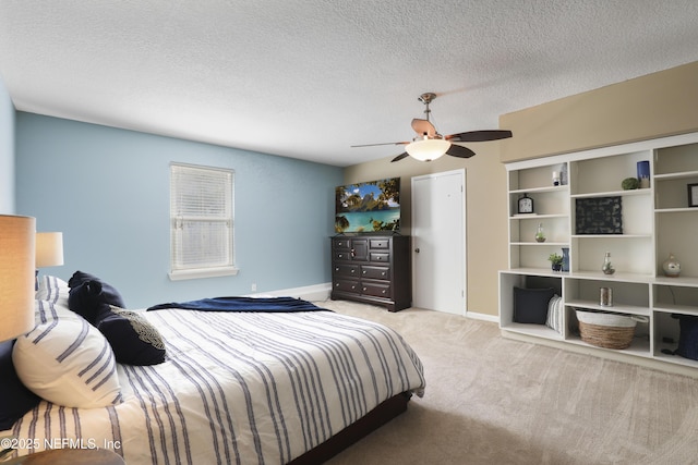 bedroom with a textured ceiling, carpet, a ceiling fan, and baseboards