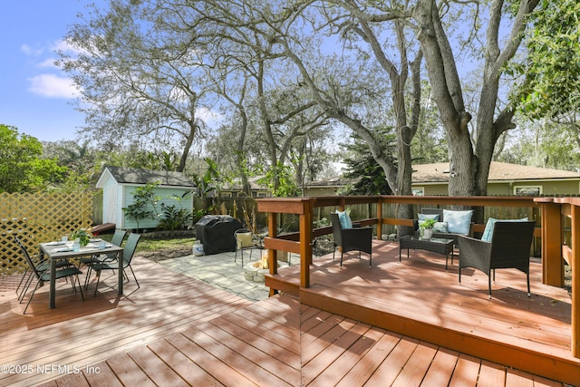 deck with an outbuilding, a storage shed, outdoor lounge area, area for grilling, and outdoor dining space