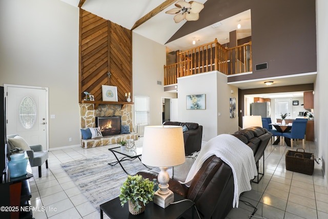 tiled living room featuring a fireplace, visible vents, ceiling fan, high vaulted ceiling, and baseboards