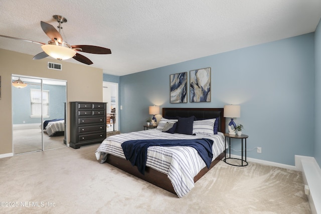 carpeted bedroom featuring baseboards, visible vents, ceiling fan, a textured ceiling, and a closet