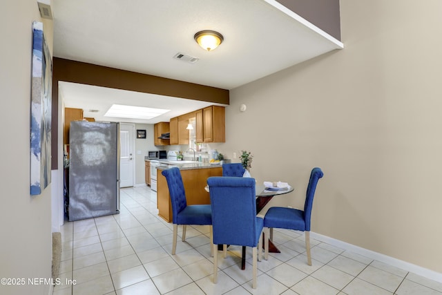 dining area featuring light tile patterned floors, visible vents, and baseboards