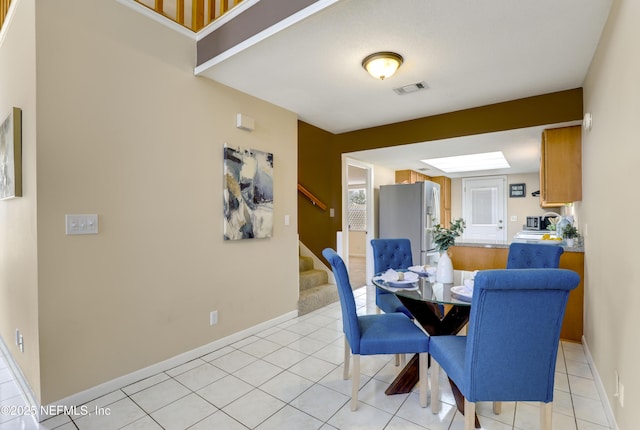 dining room featuring light tile patterned floors, stairway, visible vents, and baseboards