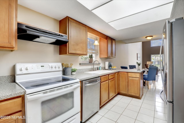 kitchen with light tile patterned floors, under cabinet range hood, a sink, light countertops, and appliances with stainless steel finishes