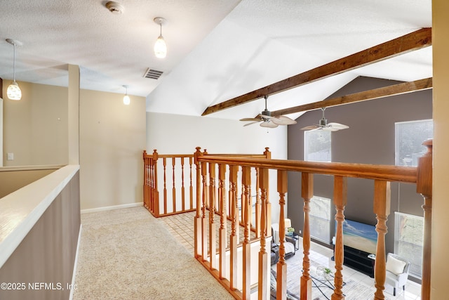 hallway with vaulted ceiling with beams, a textured ceiling, carpet floors, visible vents, and baseboards