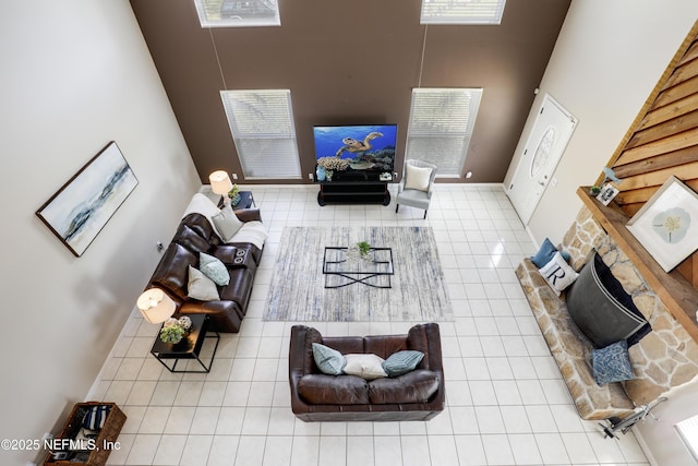 tiled living area featuring a towering ceiling