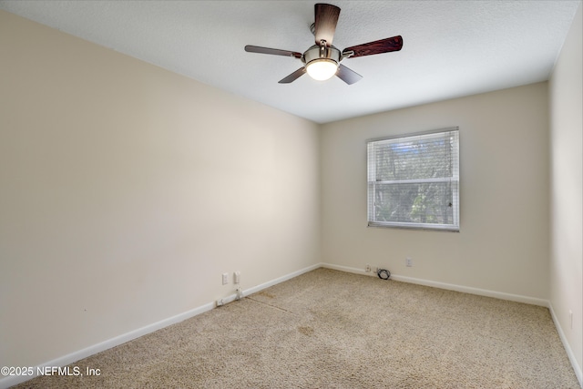 spare room featuring a ceiling fan, carpet, and baseboards