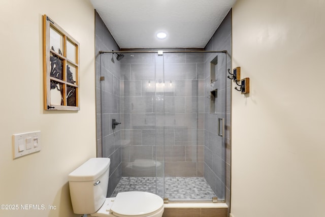 bathroom with a shower stall and toilet