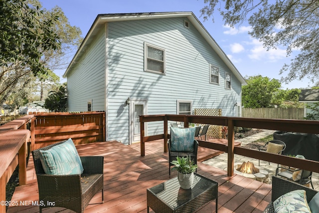 wooden deck with fence, a fire pit, and area for grilling