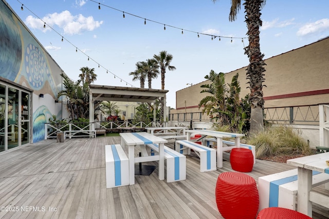 wooden terrace featuring outdoor dining area and a gazebo