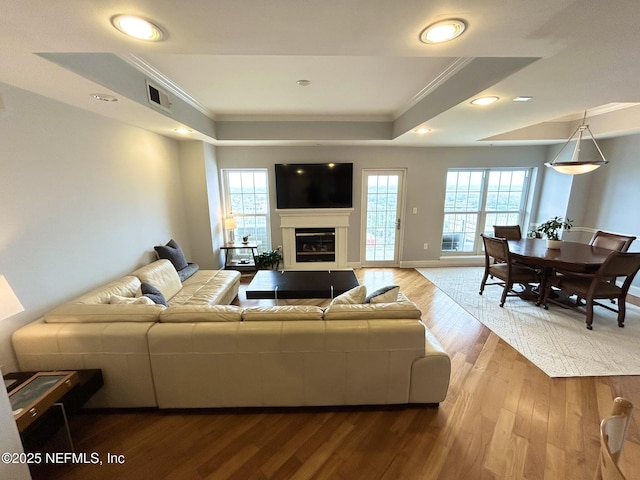 living room with ornamental molding, hardwood / wood-style floors, and a wealth of natural light