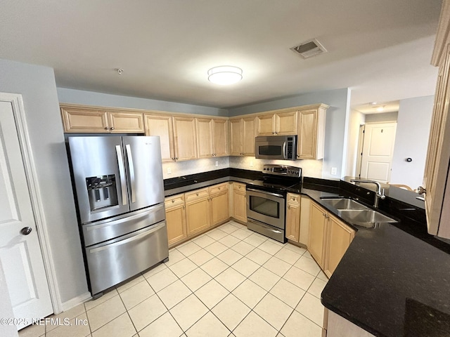 kitchen with light brown cabinetry, sink, light tile patterned flooring, and appliances with stainless steel finishes