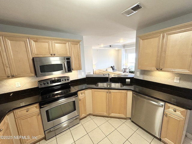 kitchen featuring sink, decorative backsplash, stainless steel appliances, and light brown cabinets