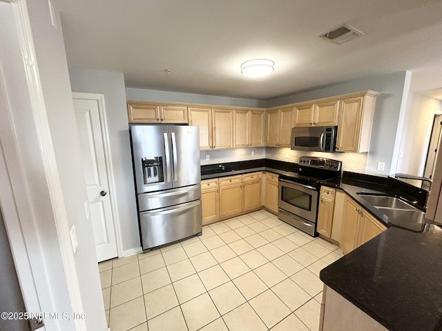 kitchen with light tile patterned floors, stainless steel appliances, sink, and light brown cabinets