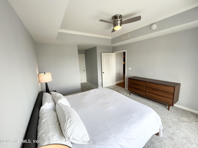 bedroom with crown molding, a tray ceiling, light colored carpet, and ceiling fan