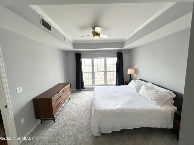 bedroom with a raised ceiling, ornamental molding, light colored carpet, and ceiling fan